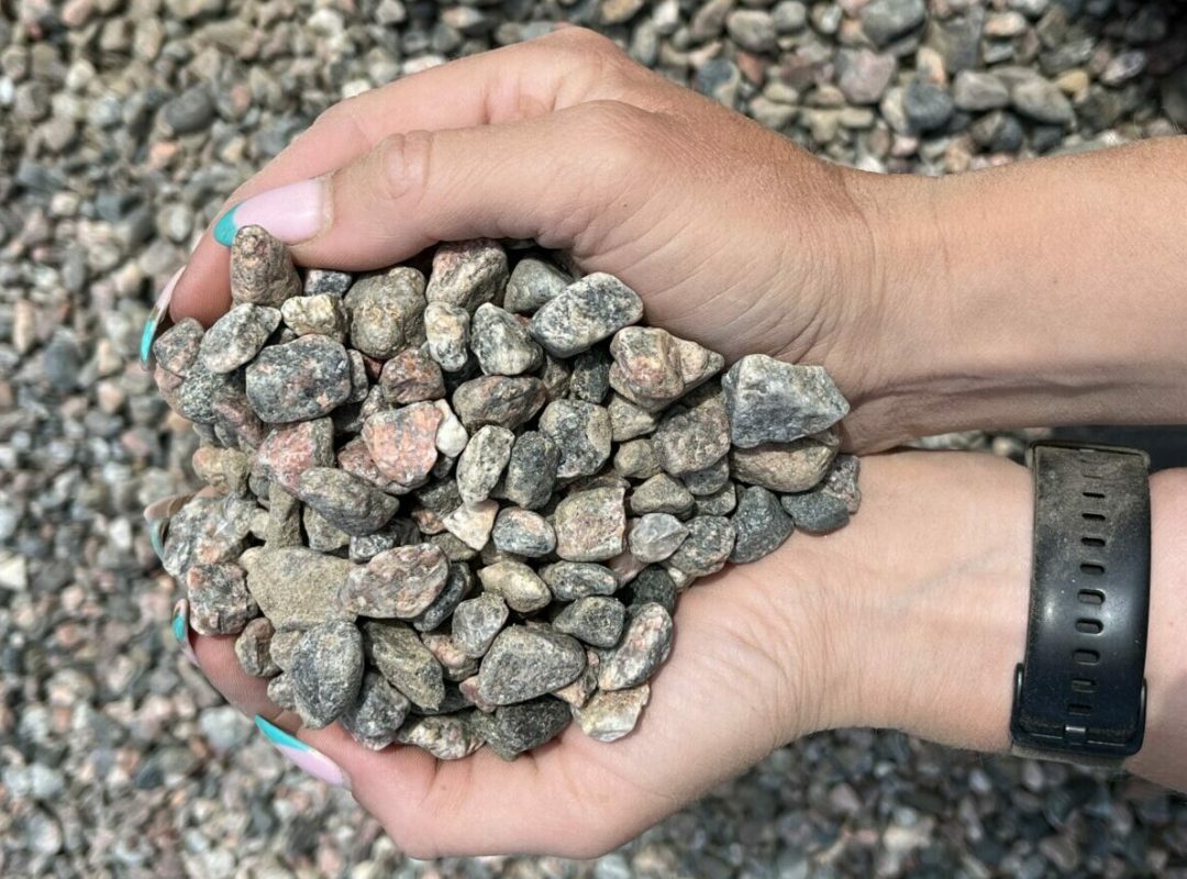 Hand som håller i gårdsgrus