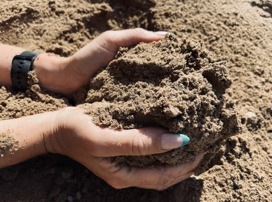 Sandlådesand i händer